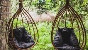 Деревянное кресло в саду – удобство в простом варианте